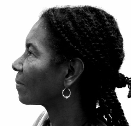 Side profile of a woman in braids with an earring.